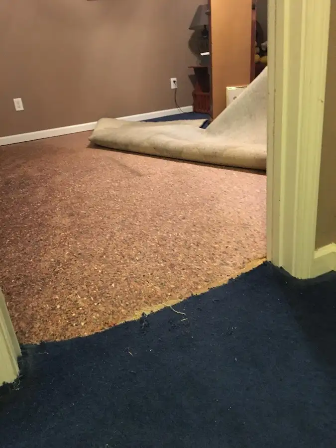 Carpet pad removal revealing water damage during Water Mitigation Services in Clemmons